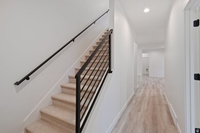Stairway featuring wood finished floors and recessed lighting