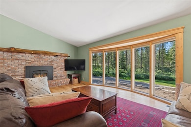 Large windows in the living room bring the outside in and the brick fireplace keeps you toasty in the winter