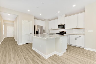 Kitchen featuring white cabinetry, a center island