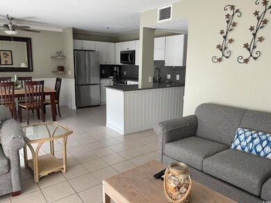 Living area with a ceiling fan and light tile patterned flooring