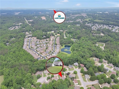 Aerial view of residential area with a large body of water and a forest