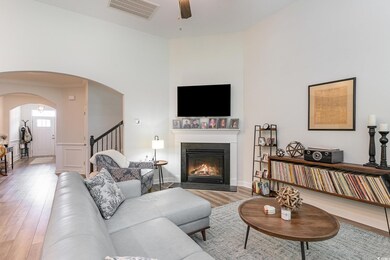 Living room with ceiling fan and light hardwood / 