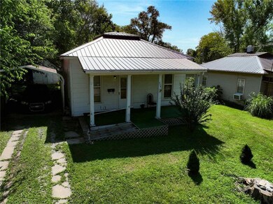 View of front of home with a metal roof and a front yard