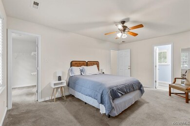 Primary Bedroom with walk-in closet, ceiling fan,