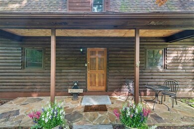 Doorway to property featuring roof with shingles and covered porch