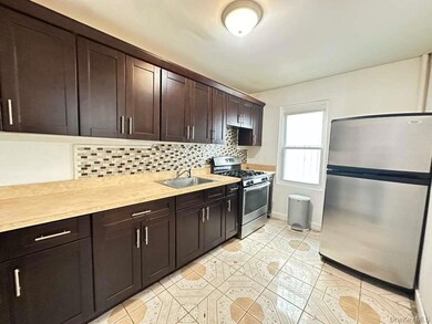 Kitchen with dark brown cabinetry, tasteful backsplash, stainless steel appliances, and light countertops