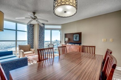 Dining space featuring ceiling fan, a textured cei
