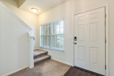 Entrance foyer featuring stairway and baseboards