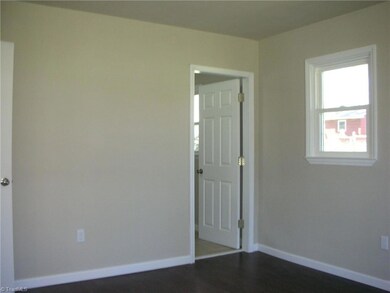 Primary Bedroom: Features include vinyl plank flooring for easy cleaning, 2 windows for natural lighting, a ceiling fan with light and fresh paint. The open door on the right is to the primary bathroom, and the door to the left is the entry door.