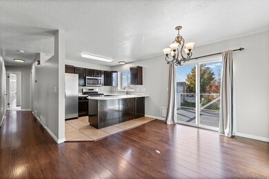 Kitchen with dark brown cabinets, a textured ceiling, light countertops, a peninsula, and light wood-style floors