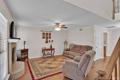 Living room featuring ceiling fan, light wood-type