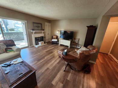 Living room featuring baseboards, a fireplace, woo