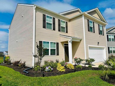 View of front facade featuring a garage and a front yard