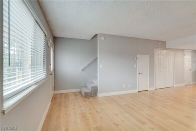Bright living room with view of stairs and faux wo