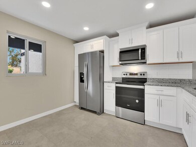 Kitchen featuring white cabinetry, baseboards, dec