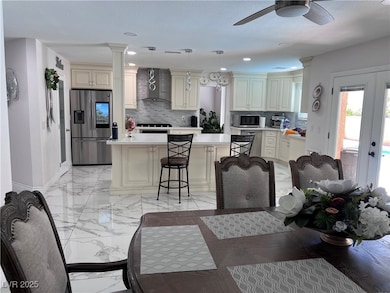 Dining area with decorative columns, a ceiling fan