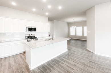 This is a chef's kitchen with a 5-burner gas range and lots of cabinet space. The dining room is adjacent to the kitchen