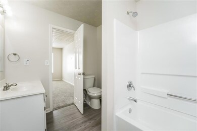 Full bath featuring vanity, wood finished floors, tub / shower combination, and a textured ceiling