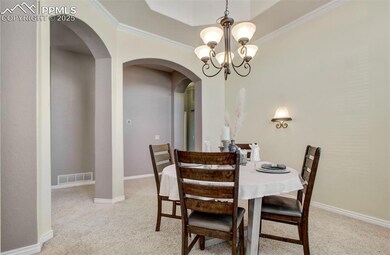 Dining room with light colored carpet, visible ven