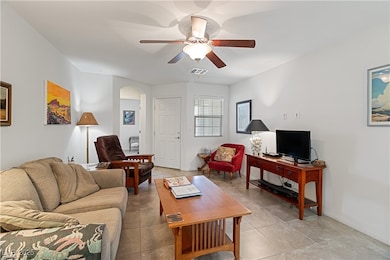 Tiled living area with ceiling fan and arched walkways