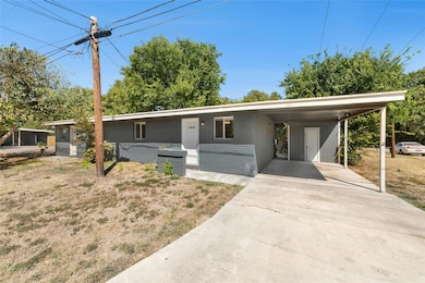 Mid-century inspired home with an attached carport and driveway