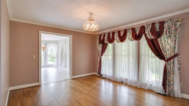 Formal dining room with hardwood floors and window looking out to the front porch.