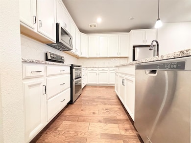 Kitchen with stainless steel appliances, backsplas