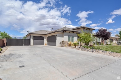 View of front of home featuring a tiled roof, a gate, concrete driveway, an attached garage, and stucco siding