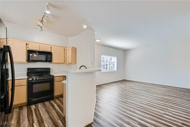 Kitchen with black appliances, dark wood-type floo
