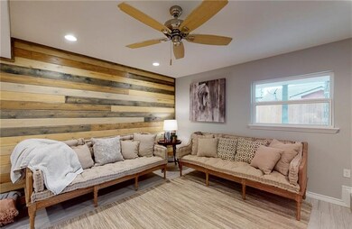 Living area with wood accent wall, recessed lighti