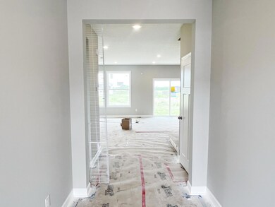 Front entry flows toward main level guest suite and family room.