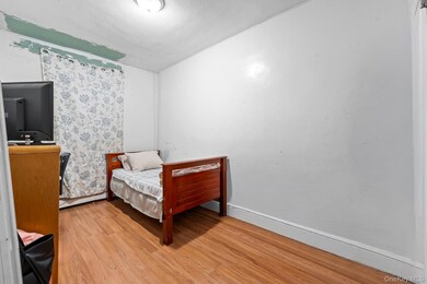 Bedroom featuring light wood-type flooring and a baseboard heating unit