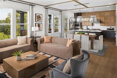 open concept living room with warm wood finished floors and recessed lighting with an abundance of natural light. Photo is representative of the Acworth Model Home. Designer features will vary.