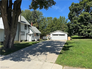 View of property exterior with an outdoor structure, a yard, a garage, and a chimney