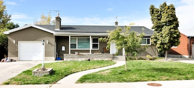 Single story home with an attached garage, a front yard, a porch, and a chimney