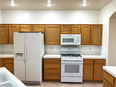 Kitchen featuring brown cabinets, tile counters, a