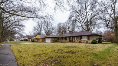 Single story home with a garage and a front yard