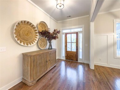 Entrance foyer with crown molding and dark hardwoo