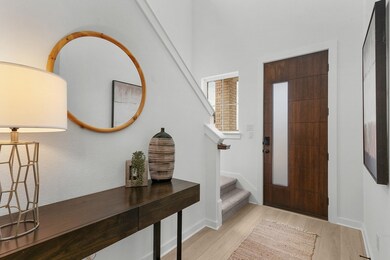 Foyer entrance with light wood-style flooring, st
