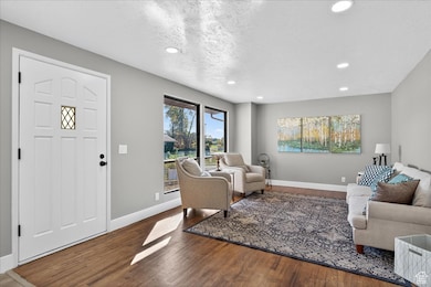 Living area with wood finished floors, recessed lighting, and a textured ceiling
