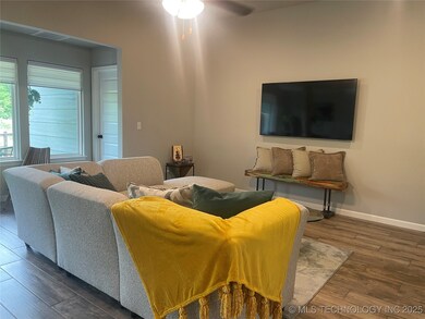 Living room featuring wood finished floors, ceiling fan, and baseboards