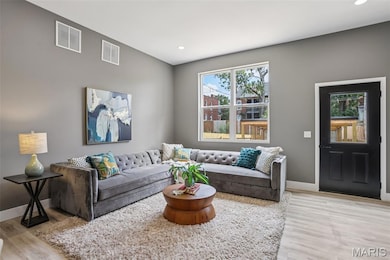 Living area featuring light wood-type flooring and recessed lighting