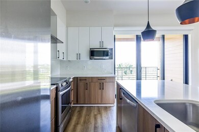The gourmet kitchen showcases sleek white cabinetry and elegant quartz countertops with waterfall detailing premium stainless steel appliances, and a generous breakfast bar island-perfect for entertaining or everyday dining.