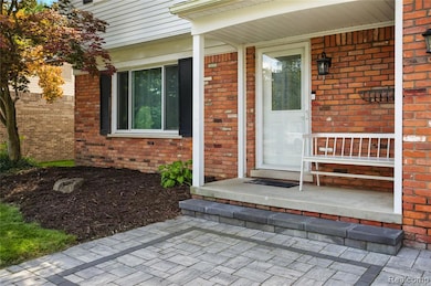 Property entrance with covered porch and brick siding
