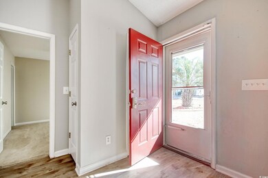 Entrance foyer with vaulted ceiling and light hard