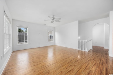 Spare room featuring a ceiling fan, arched walkway
