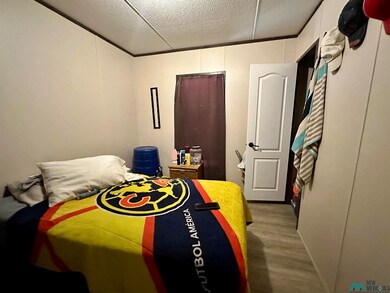 Bedroom featuring dark wood-type flooring and a textured ceiling