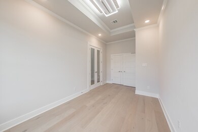 Unfurnished bedroom featuring light wood-style floors, recessed lighting, crown molding, and french doors