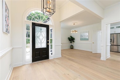 Entrance foyer with a chandelier, light wood-style