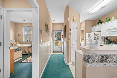 Kitchen featuring white cabinetry, light colored c